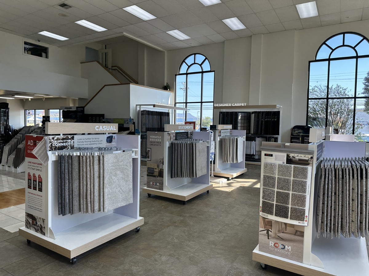 Modern carpet showroom with themed sections, neutral-toned samples, and bright, open design.